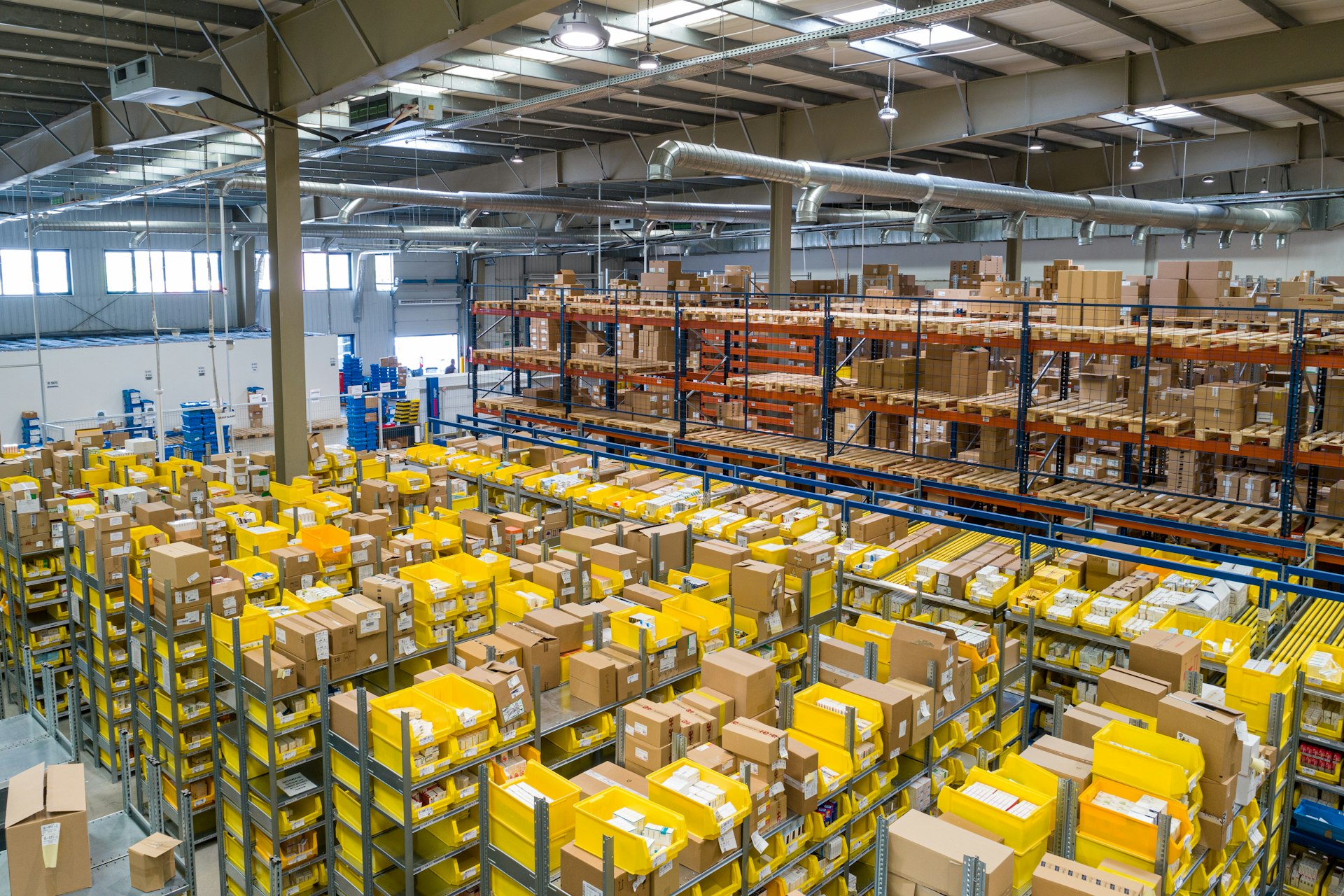 A distribution center floor with shelving and workers